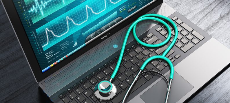 laptop with a stethescope sitting on the keyboard