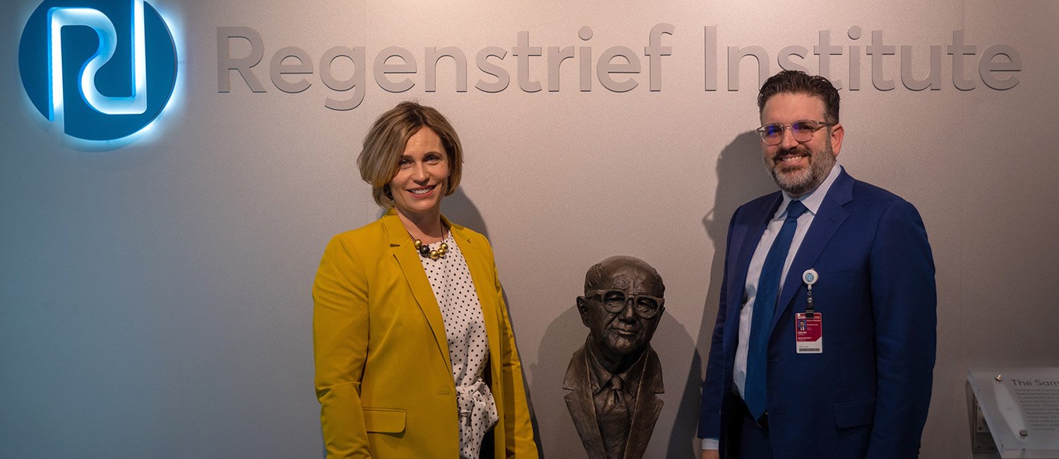 Dr. Nicole Fowler and Dr. Peter Embi pose with bust of Sam Regenstrief