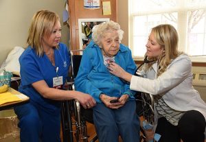 A Probari nurse and doctor tend to a woman in a wheelchair