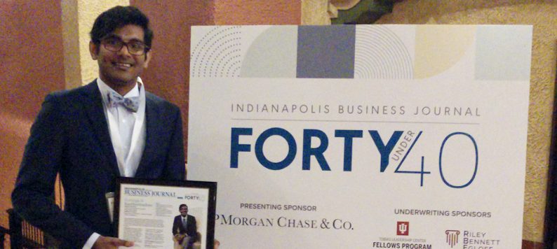 Suranga Kathurirathne holding certificate saying he is one of IBJ's 40 under 40