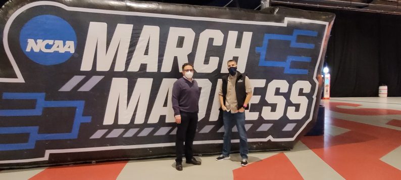 Dr. Peter Embi and Dr. Joshua Vest in front of March Madness sign