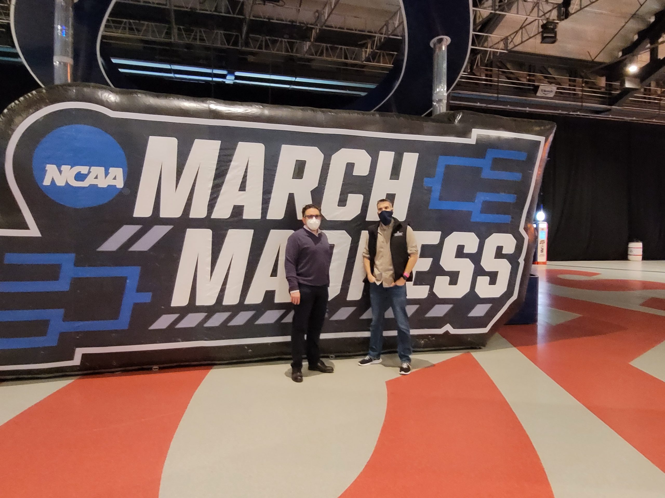 Dr. Peter Embi and Dr. Joshua Vest in front of March Madness sign