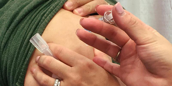 hands administering flu shot