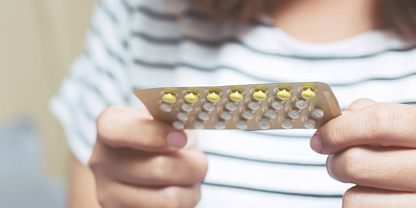 woman holding birth control pills