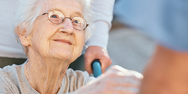 Holding hands, caregiver and senior woman in wheelchair for support outdoor in retirement home. Love, trust and healthcare nurse or medical wellness doctor for disability patient with kindness.