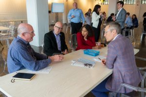 Drs. David Haggstrom, Kosali Simon and Clint Cary networking with an IU Health representative